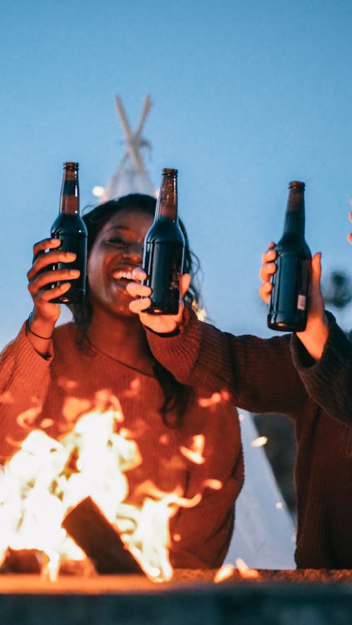 Woman with Her Friends Holding Beer Bottles