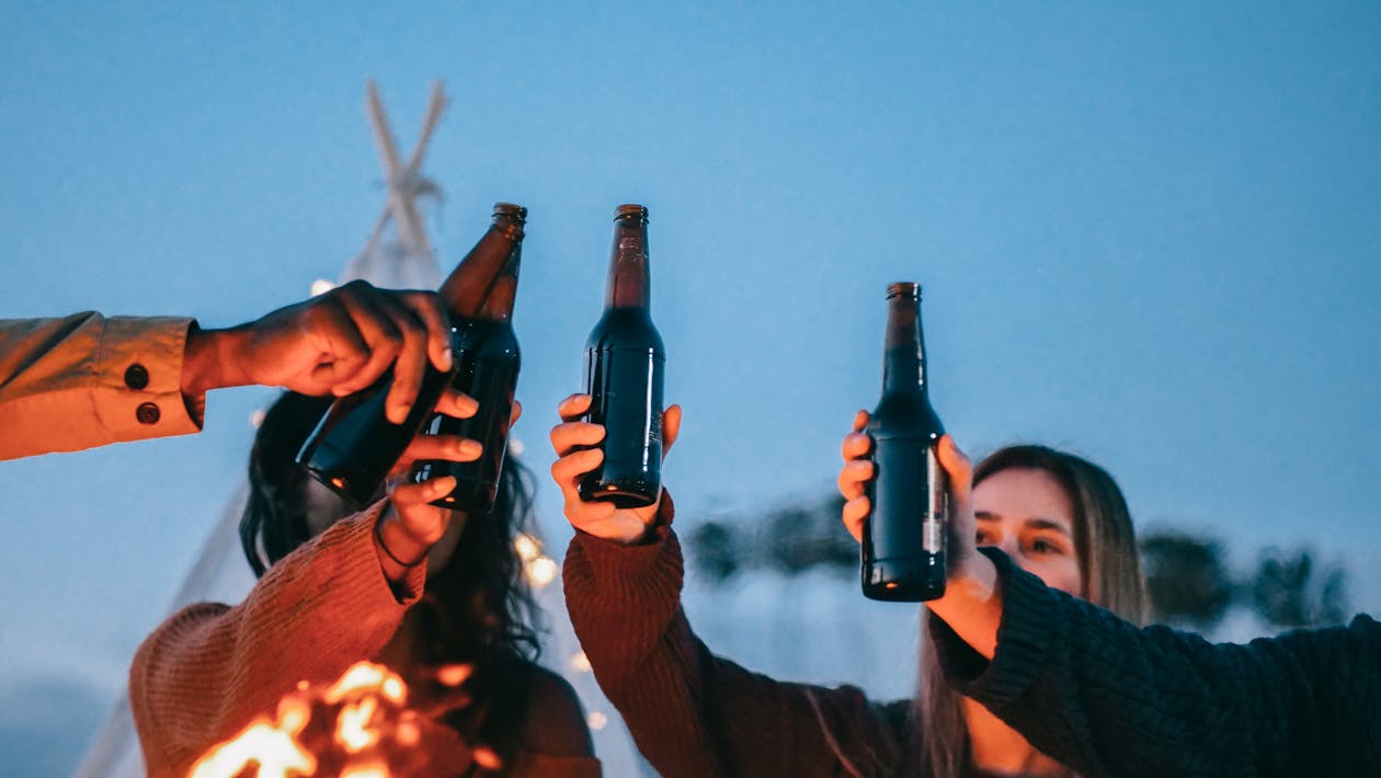 Free Group of Friends Clinking Beer Bottles Stock Photo
