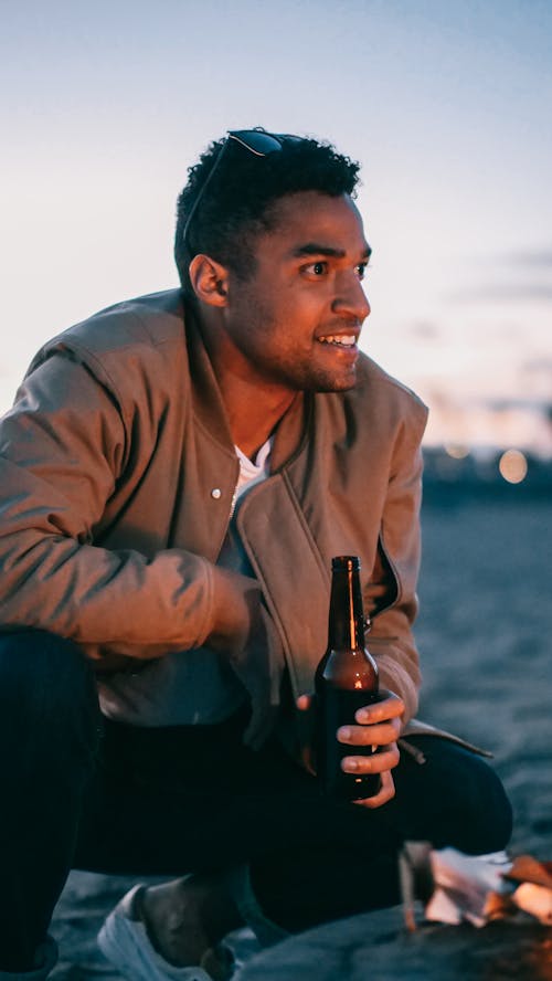 Man in Brown Jacket Holding Bottle