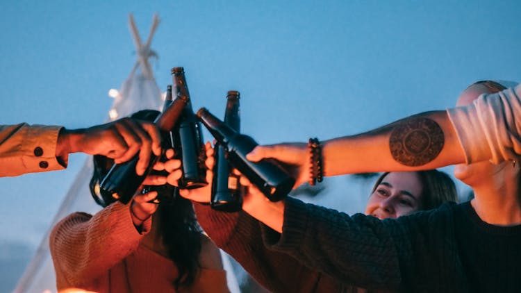 Group Of Friends Clinking Beer Bottles