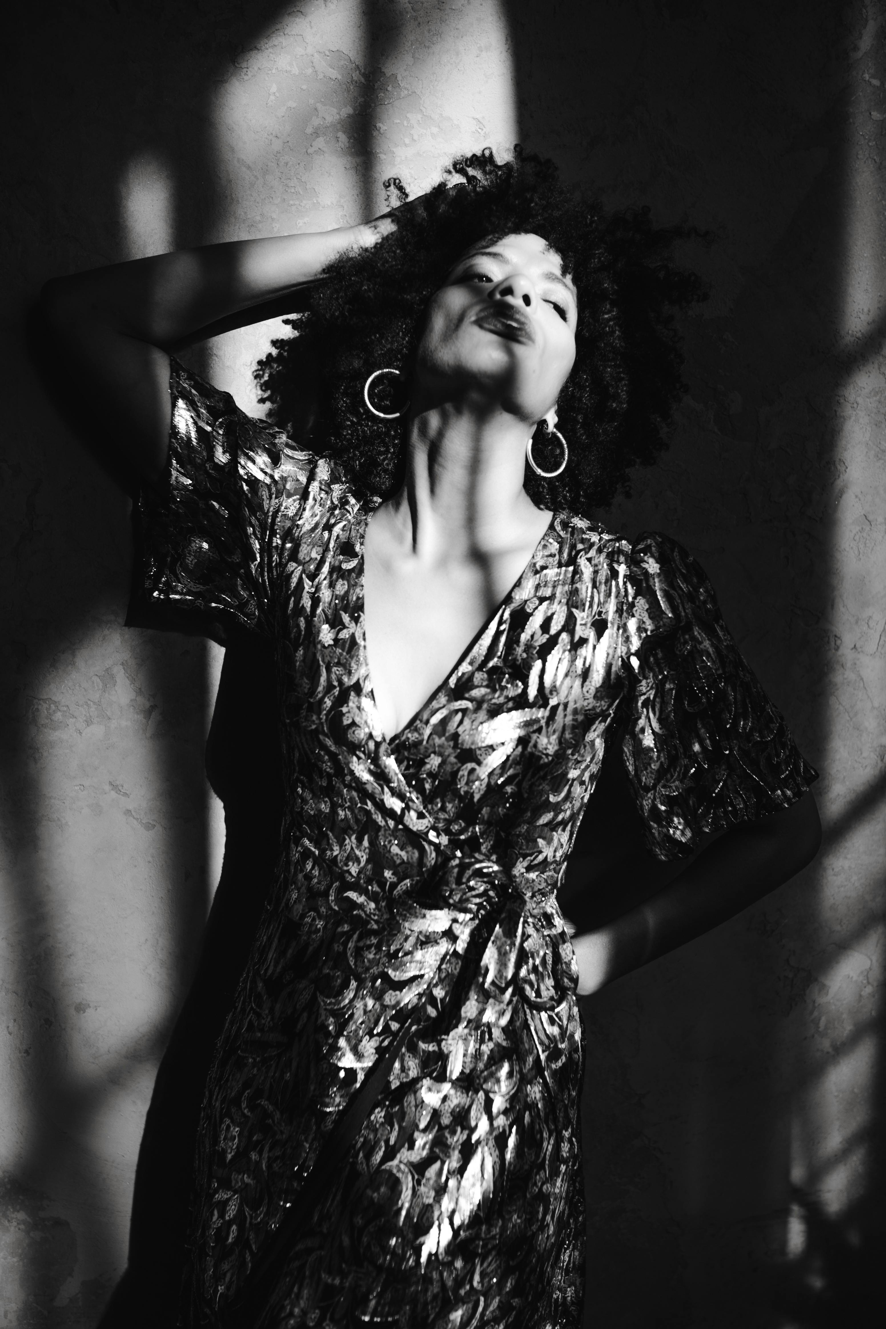 Striking black and white portrait of a woman in elegant attire, highlighting shadows.