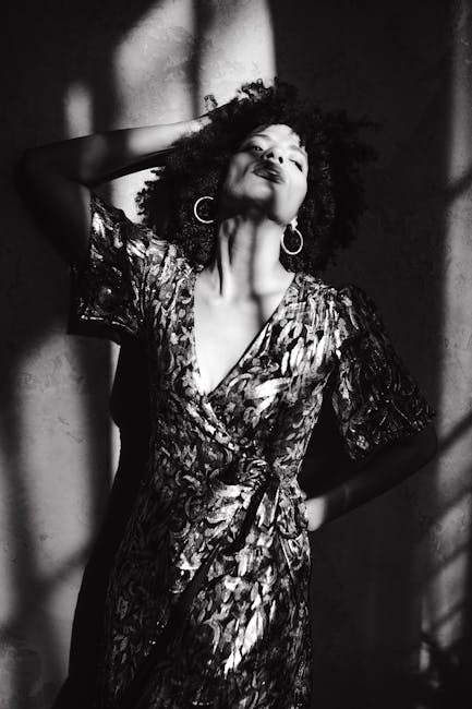 Striking black and white portrait of a woman in elegant attire, highlighting shadows.