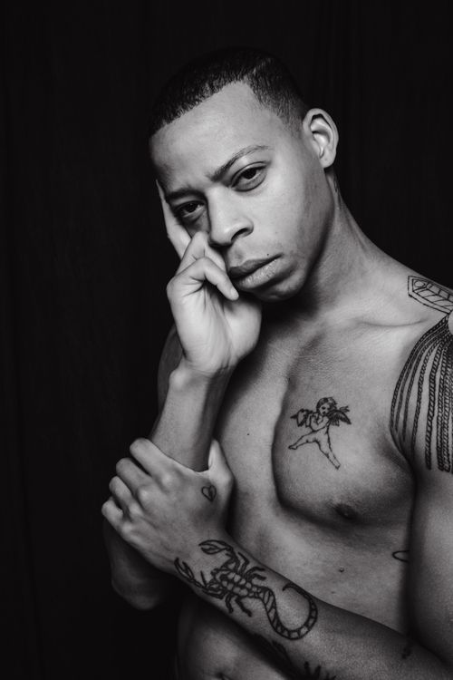 Free Grayscale studio portrait of a tattooed, topless man with thoughtful expression. Stock Photo