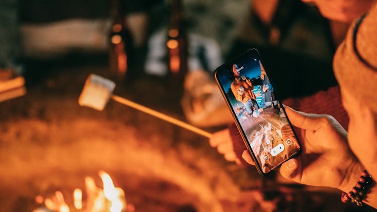 Man Recording On His Smartphone Women Roasting Marshmallow