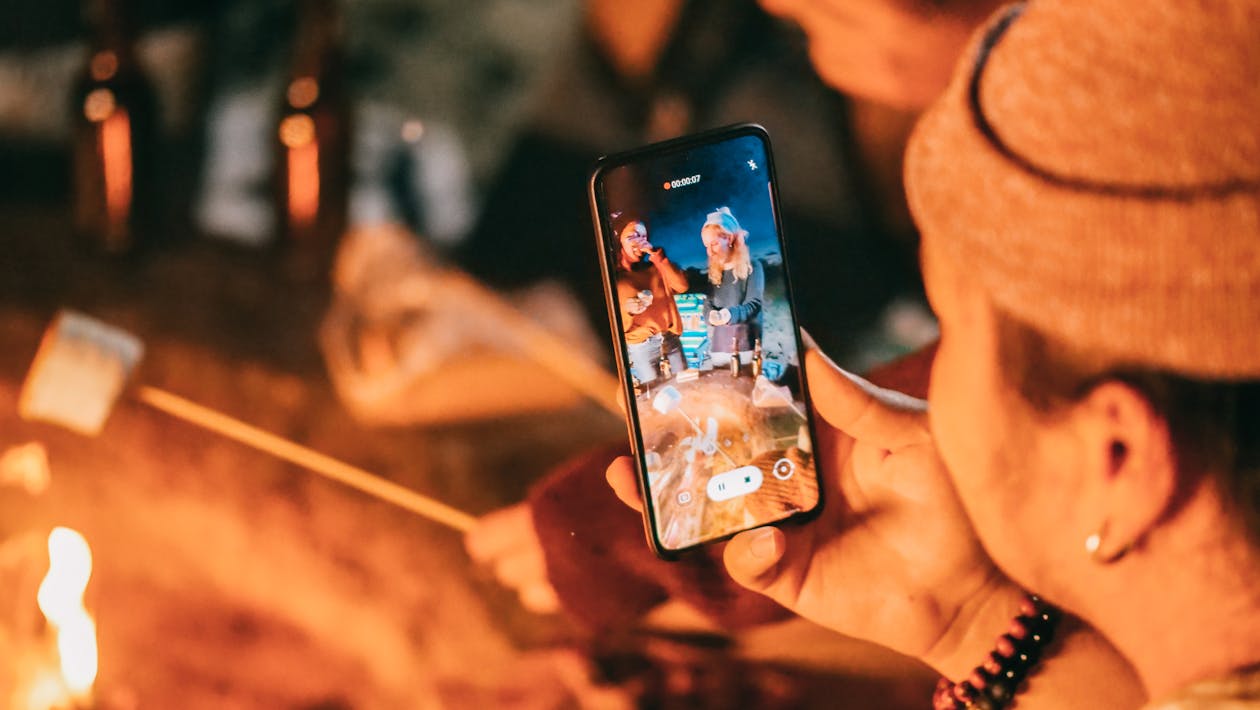 Man Recording on His Smartphone Women Roasting Marshmallow