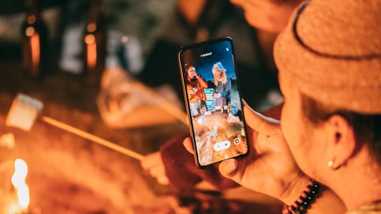 Man Recording On His Smartphone Women Roasting Marshmallow