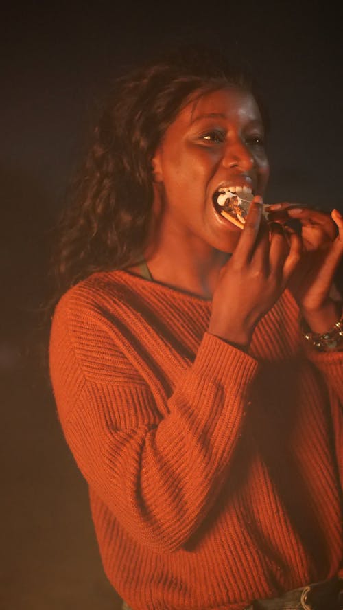 Woman in Pink Sweatshirt Eating S'mores