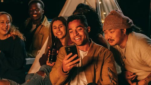 Free Man Showing His Mobile Phone to His Friends Stock Photo