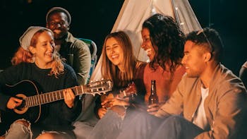 Group of Friends Singing while Sitting on Beach Sand