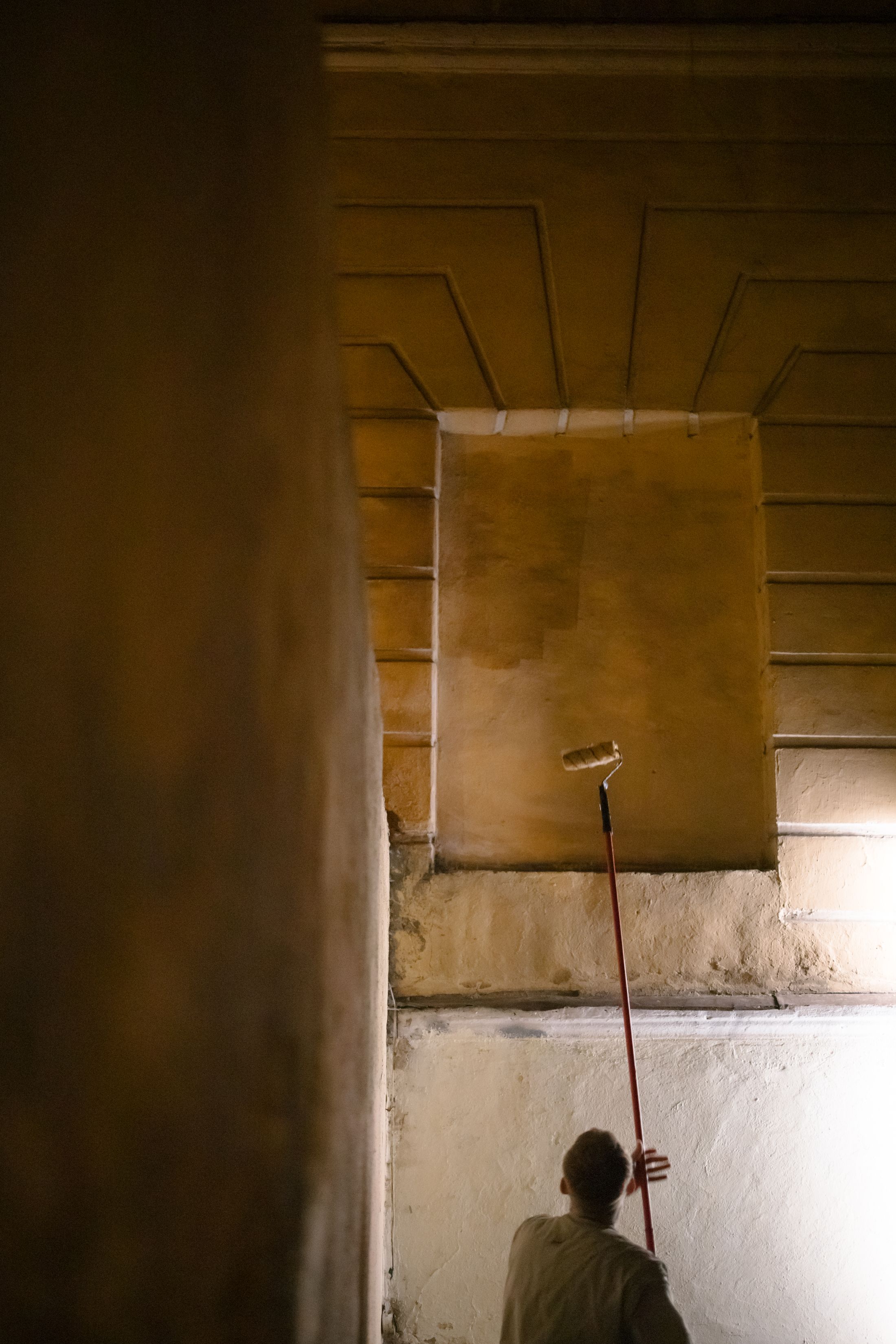 Professional painter applying a smooth finish to an interior wall