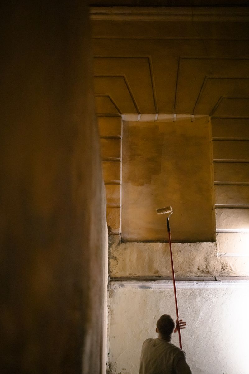 Painter cutting in walls of a large open commercial space