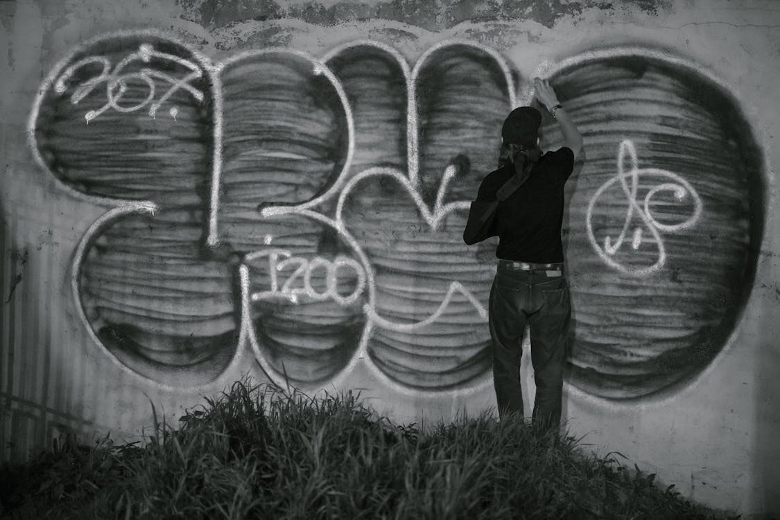 Person Creating Graffiti Art on Wall