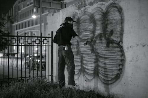 Free A Person Standing Near the Wall while Using Spray Paint Stock Photo