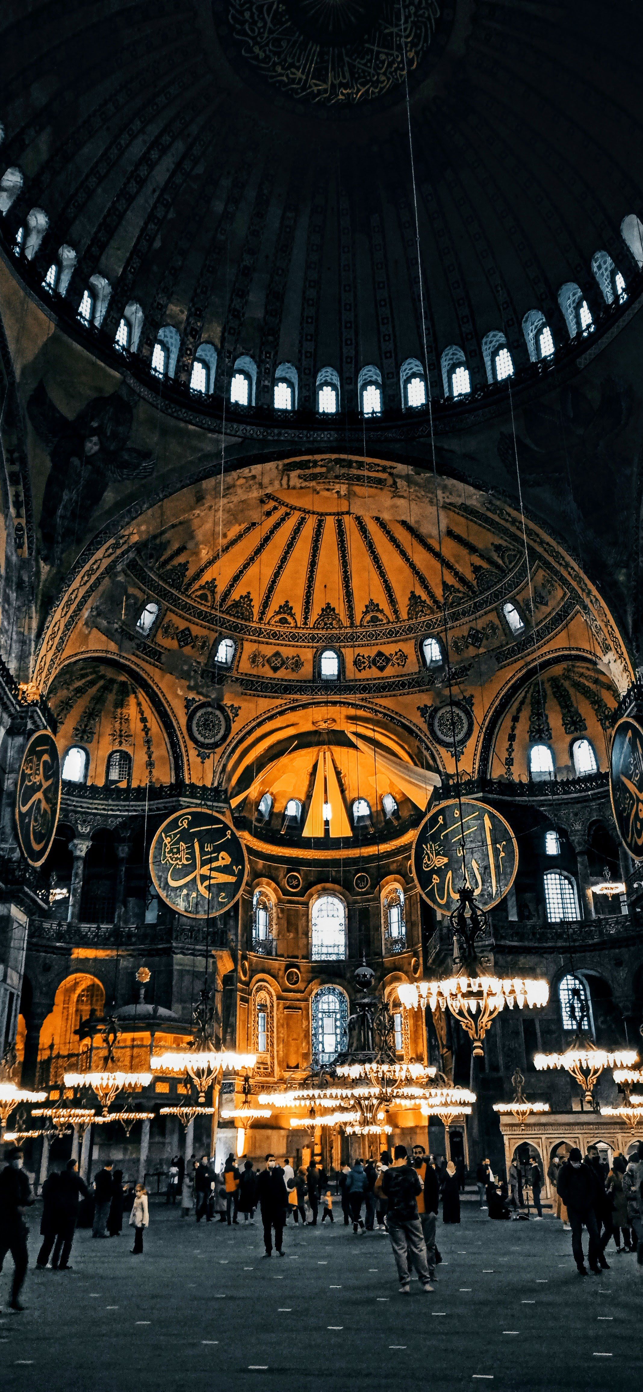 Golden-lit interior of Hagia Sophia in Istanbul, showcasing historic architectural brilliance.