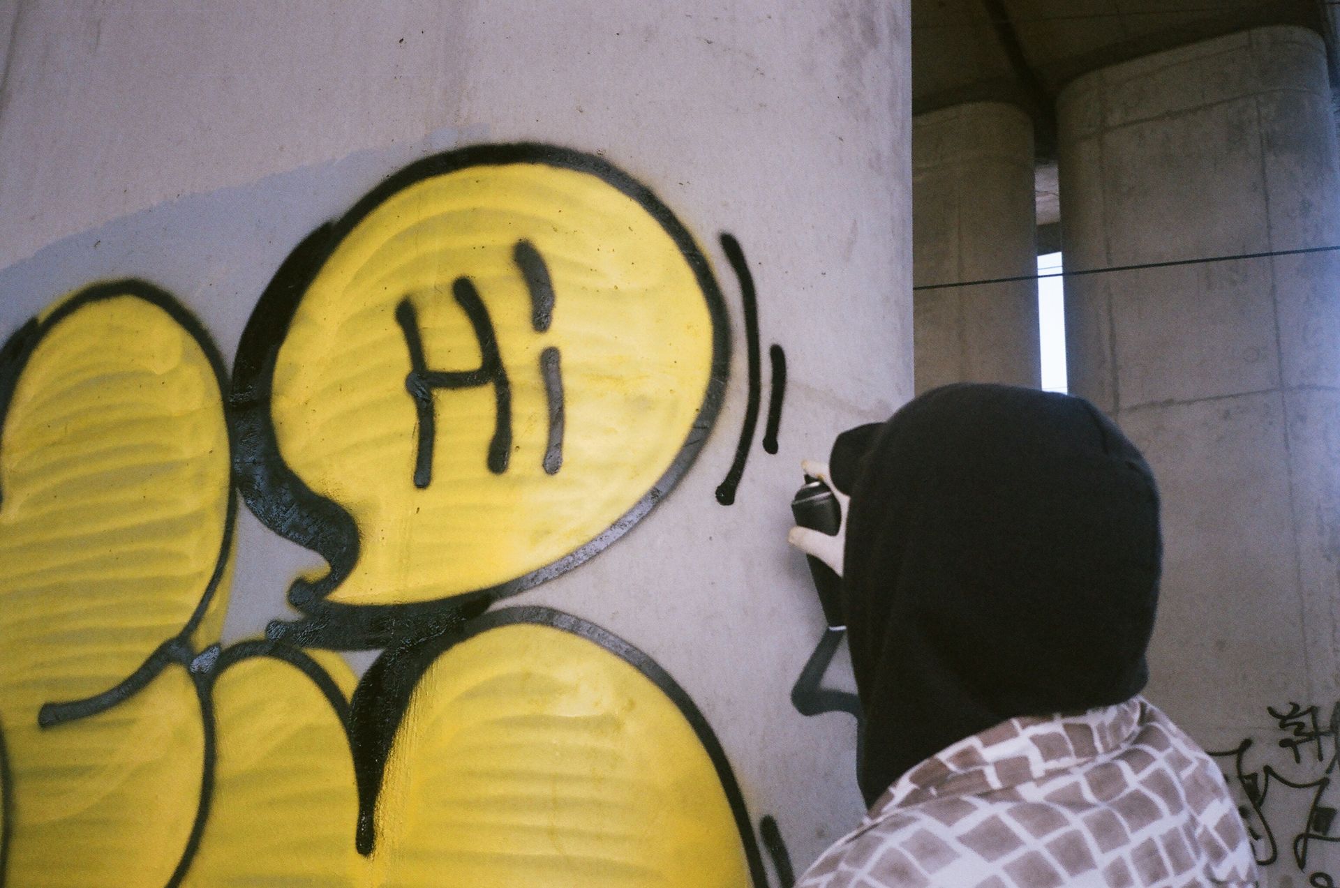 Person Spray Painting a Concrete Wall