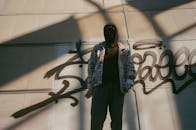 Man in Plaid Jacket Standing Beside His Wall Art