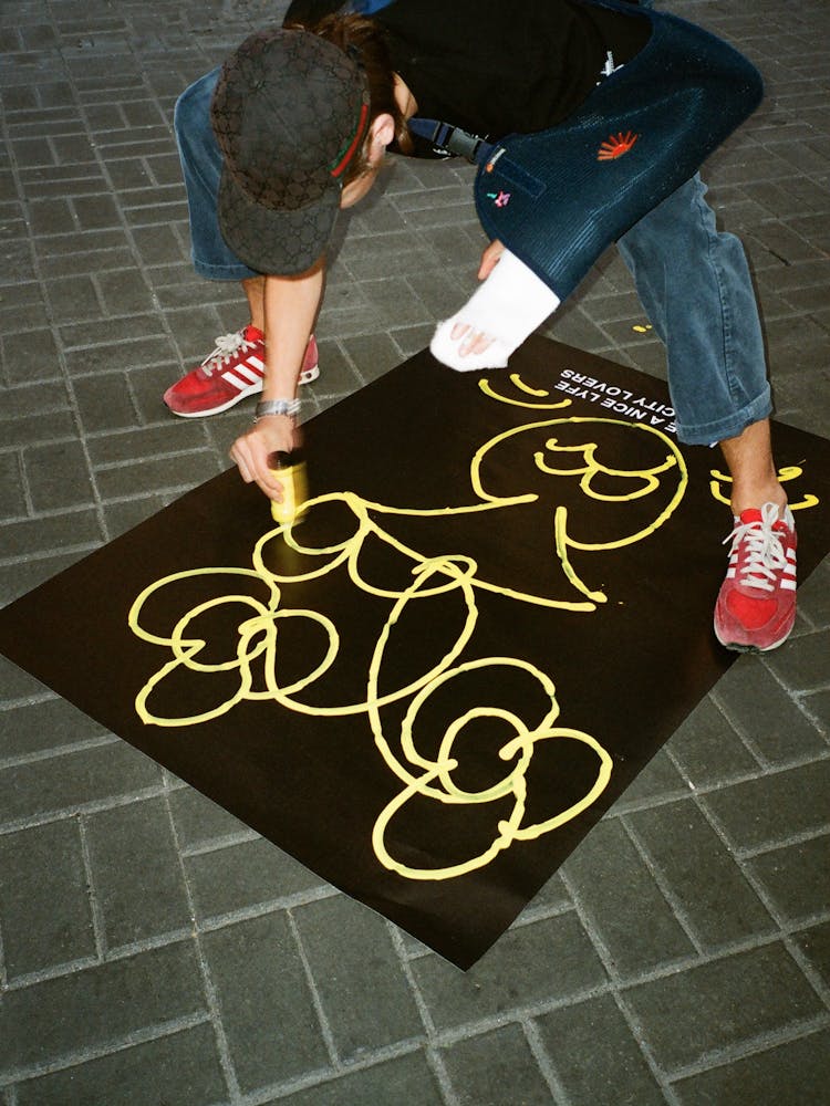 Man With A Broken Arm Painting Graffiti On A Poster 