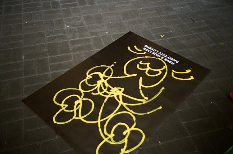 Poster Wit Graffiti Lying On A Sidewalk 