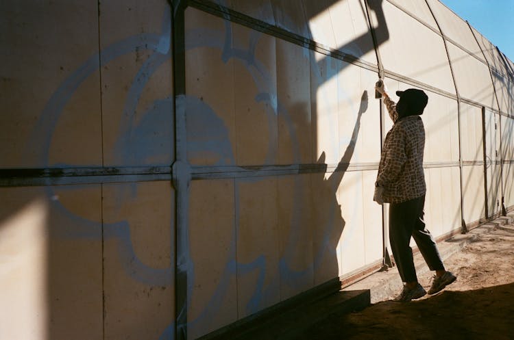 Person Drawing Graffiti On Wall