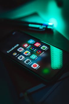 Smartphone displaying colorful app icons in low light, emphasizing technology and connectivity.