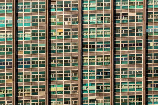 Close-up view of a high-rise building facade featuring numerous glass windows, showcasing urban architecture.