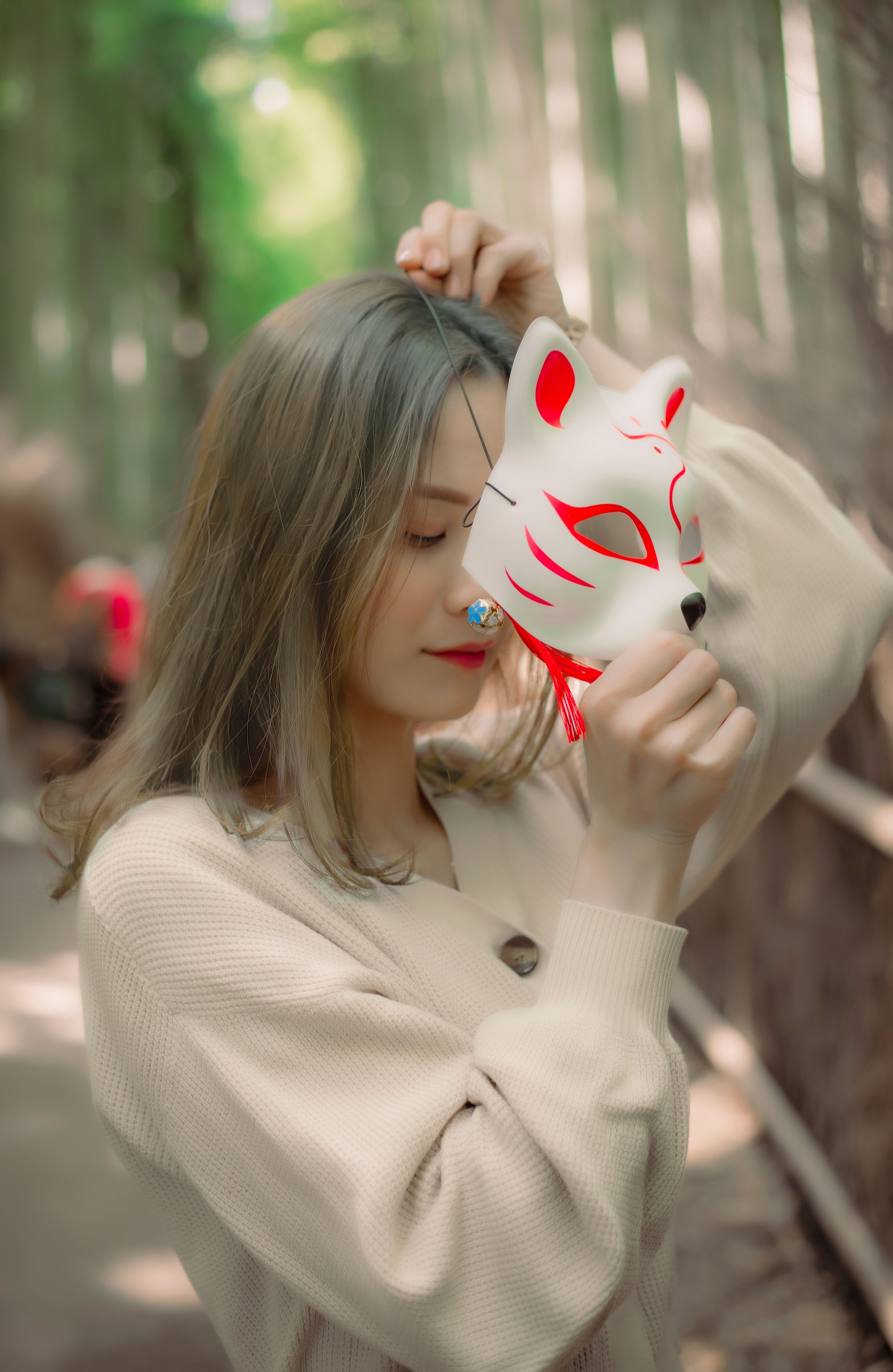 A serene portrait of a woman with a fox mask in a tranquil bamboo forest setting.