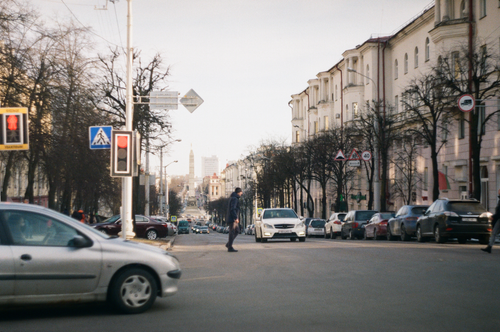 Free Street view of an urban crossing in Minsk with vehicles and a pedestrian. Stock Photo