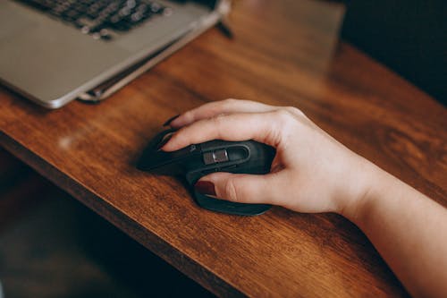 Person Holding Black Cordless Computer Mouse