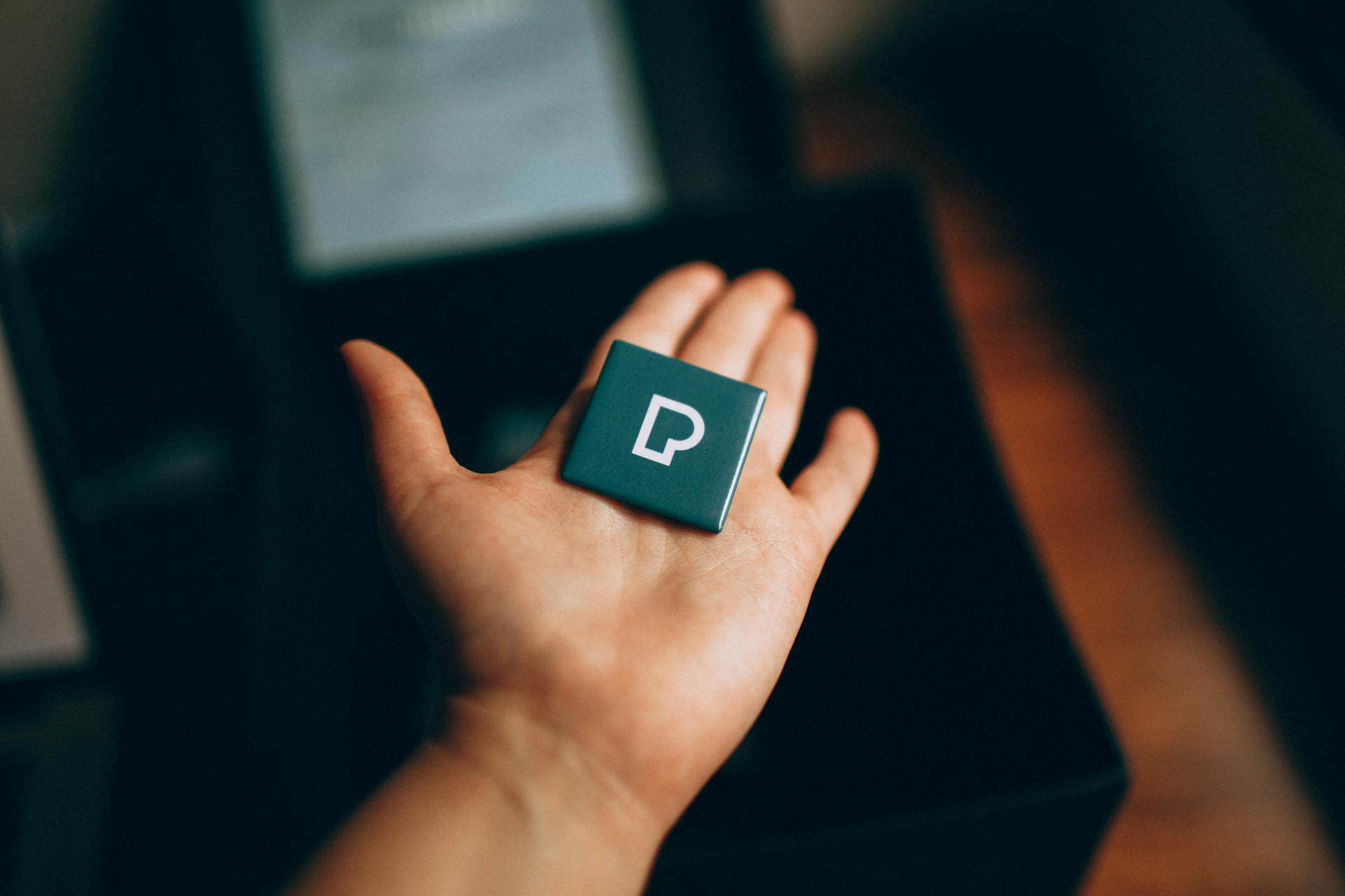 Person Holding Square Pin with Pexels Logo