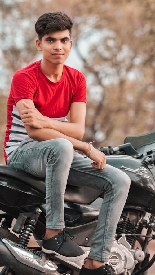Free Man in a Red Crew Neck Shirt Sitting on a Black Motorcycle Stock Photo