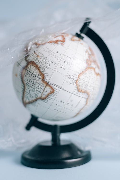 A White and Black Desk Globe Covered in a Plastic Sheet