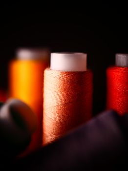 Colorful spools of thread in soft focus, perfect for sewing projects and creative crafts.