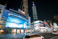 City with illuminated buildings and skyscrapers near road with cars