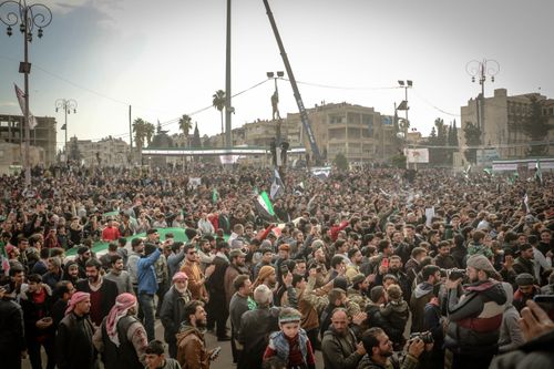 Free Large crowd protesting in Idlib, Syria, showcasing unity and activism under cloudy skies. Stock Photo