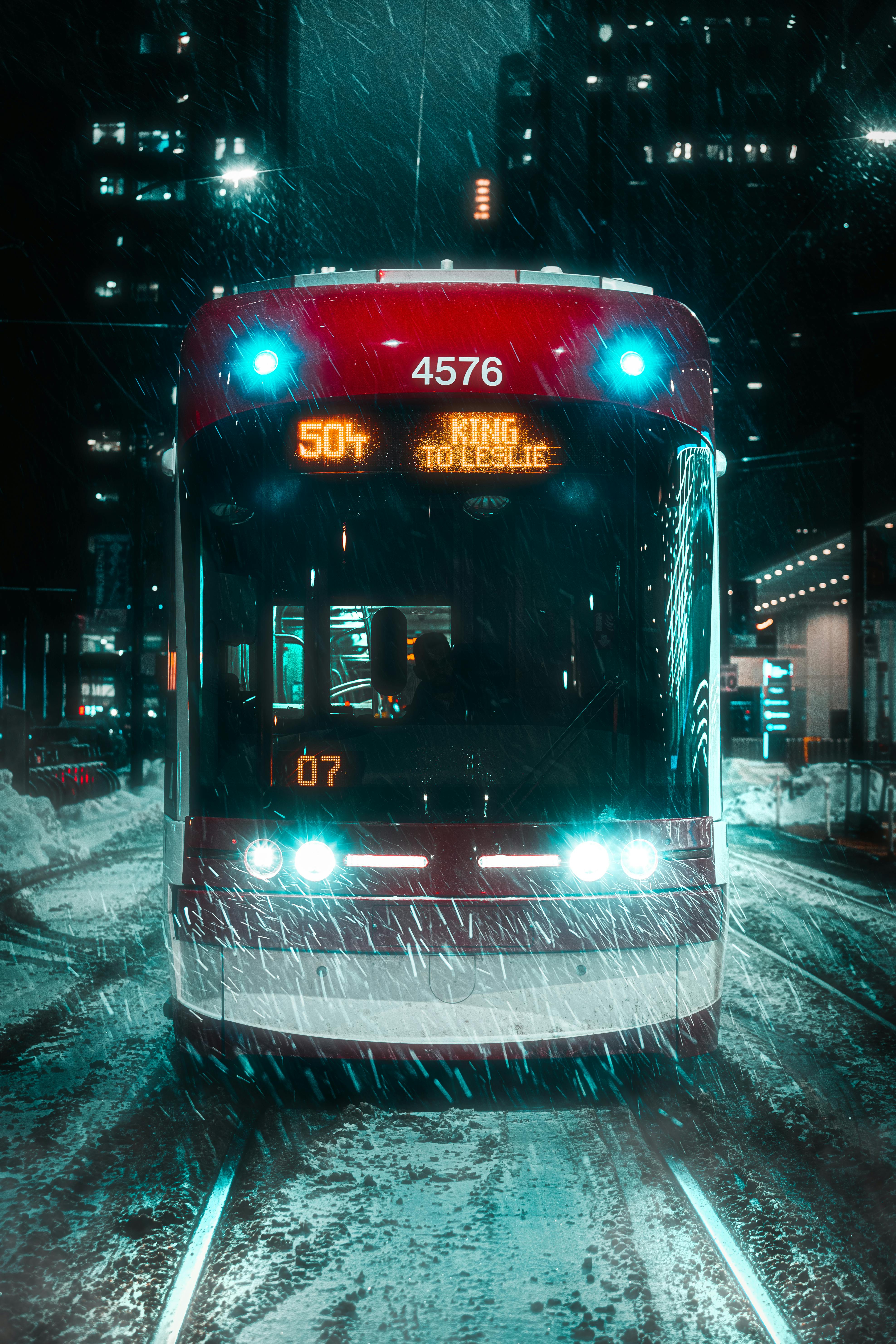Toronto streetcar navigates snowy streets at night, showcasing winter in the city.