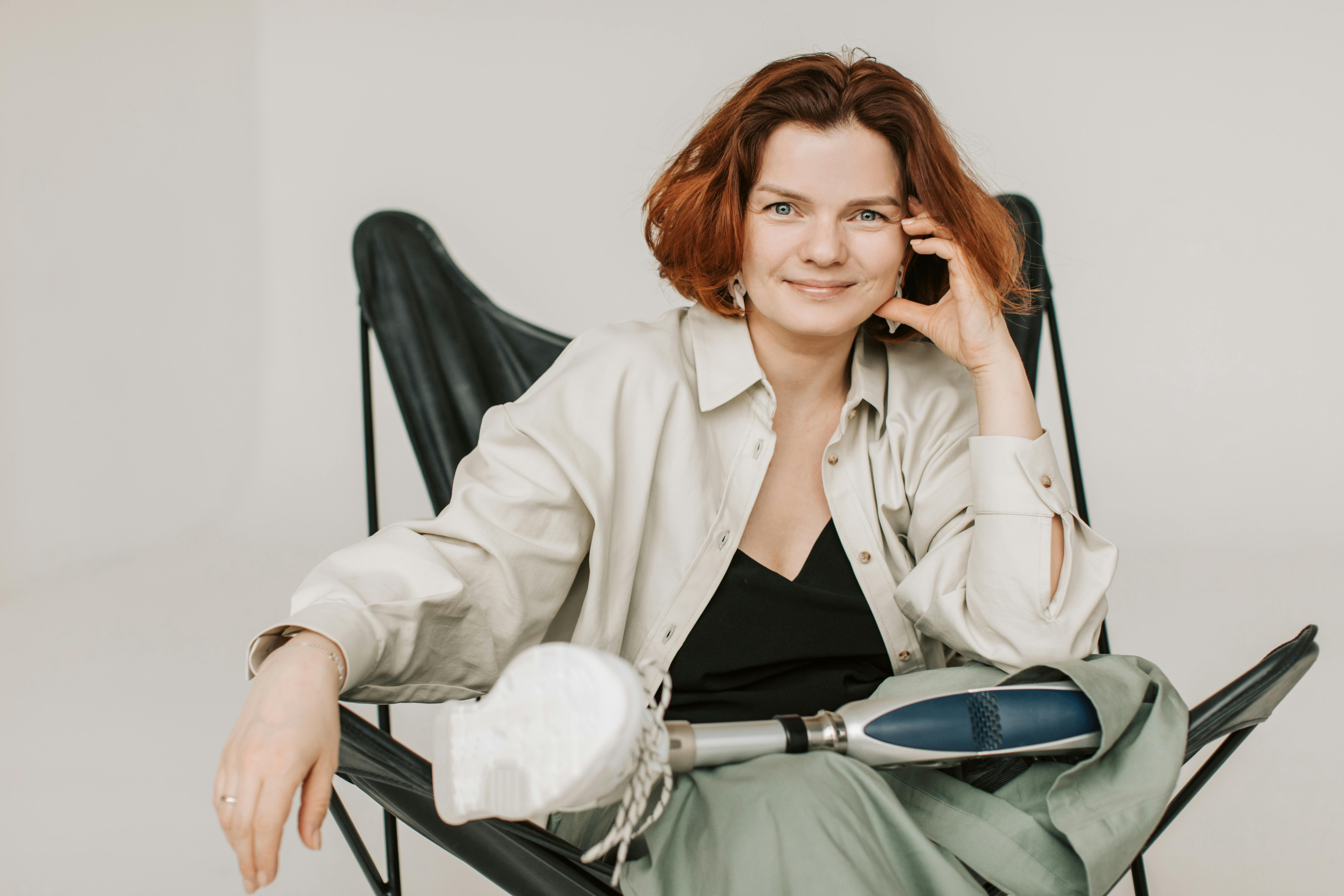 Front view of smiling female with bionic leg prosthesis sitting in