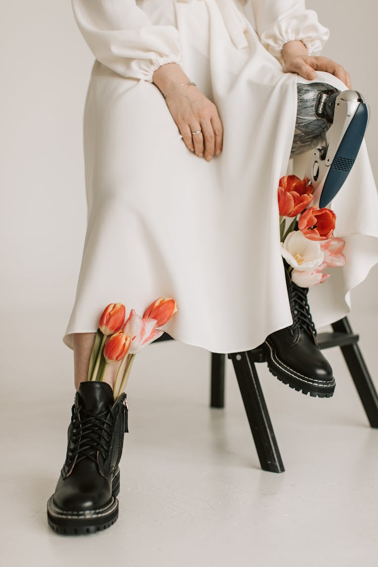 A Woman In Black Boots With Fresh Tulips