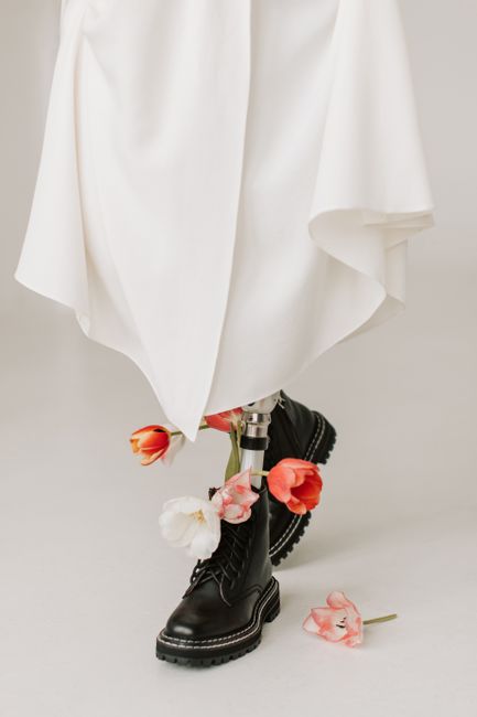 Stylish prosthetic leg adorned with flowers in a modern, minimalist setting.