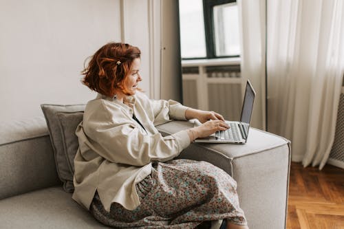 Woman sitting on a Sofa using Laptop 