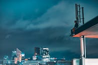 晚上，一个人坐在屋顶上，俯瞰着城市明亮的天际线