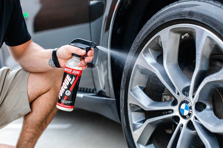 A Person Cleaning A Bmw Wheel