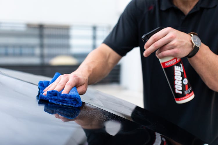 A Person In Black Shirt Cleaning Black Car