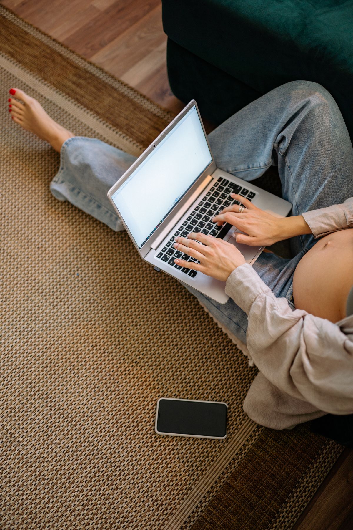 Pregnant woman working with a laptop in a comfortable room