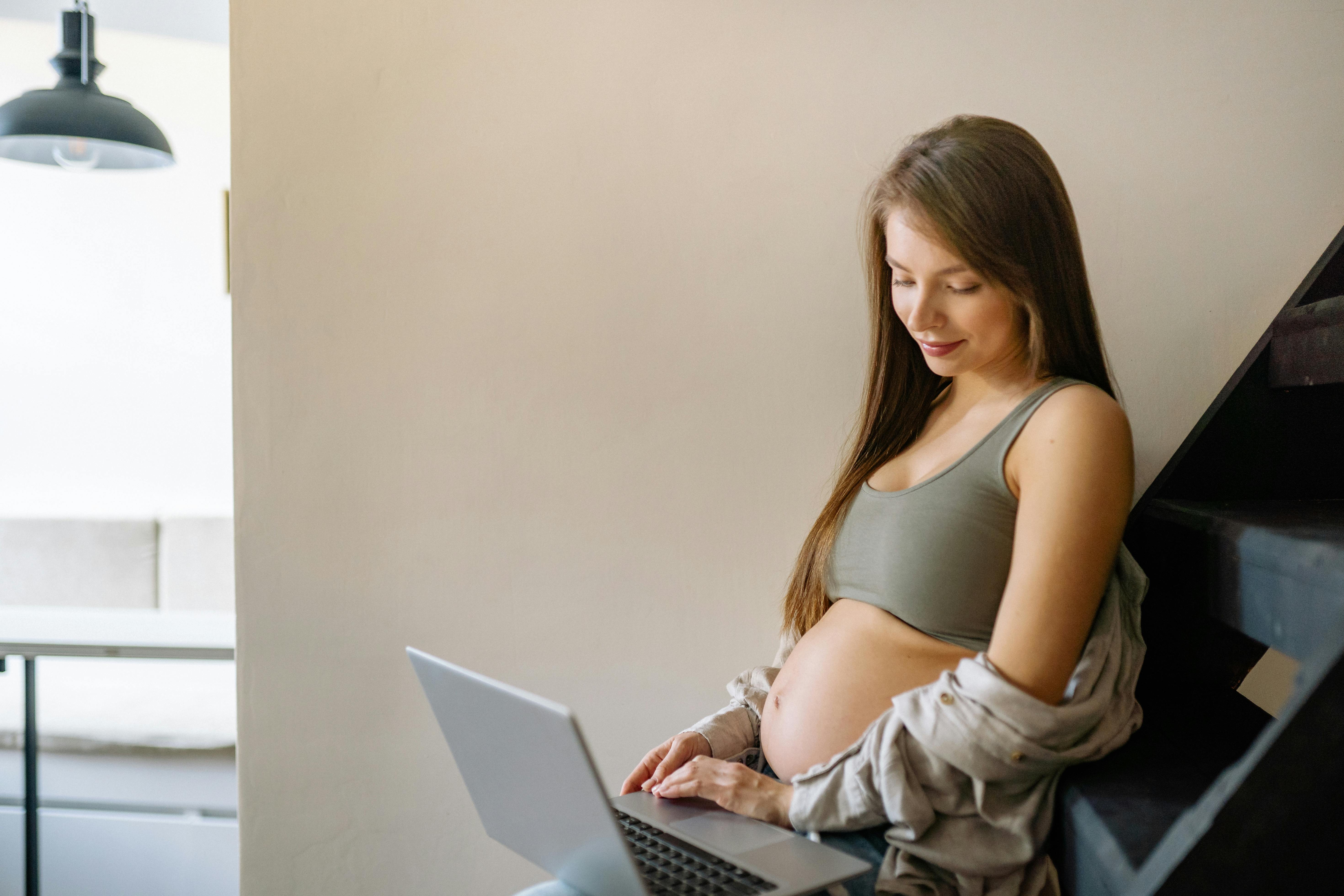 Expectant mother managing remote work from home, balancing career and maternity.