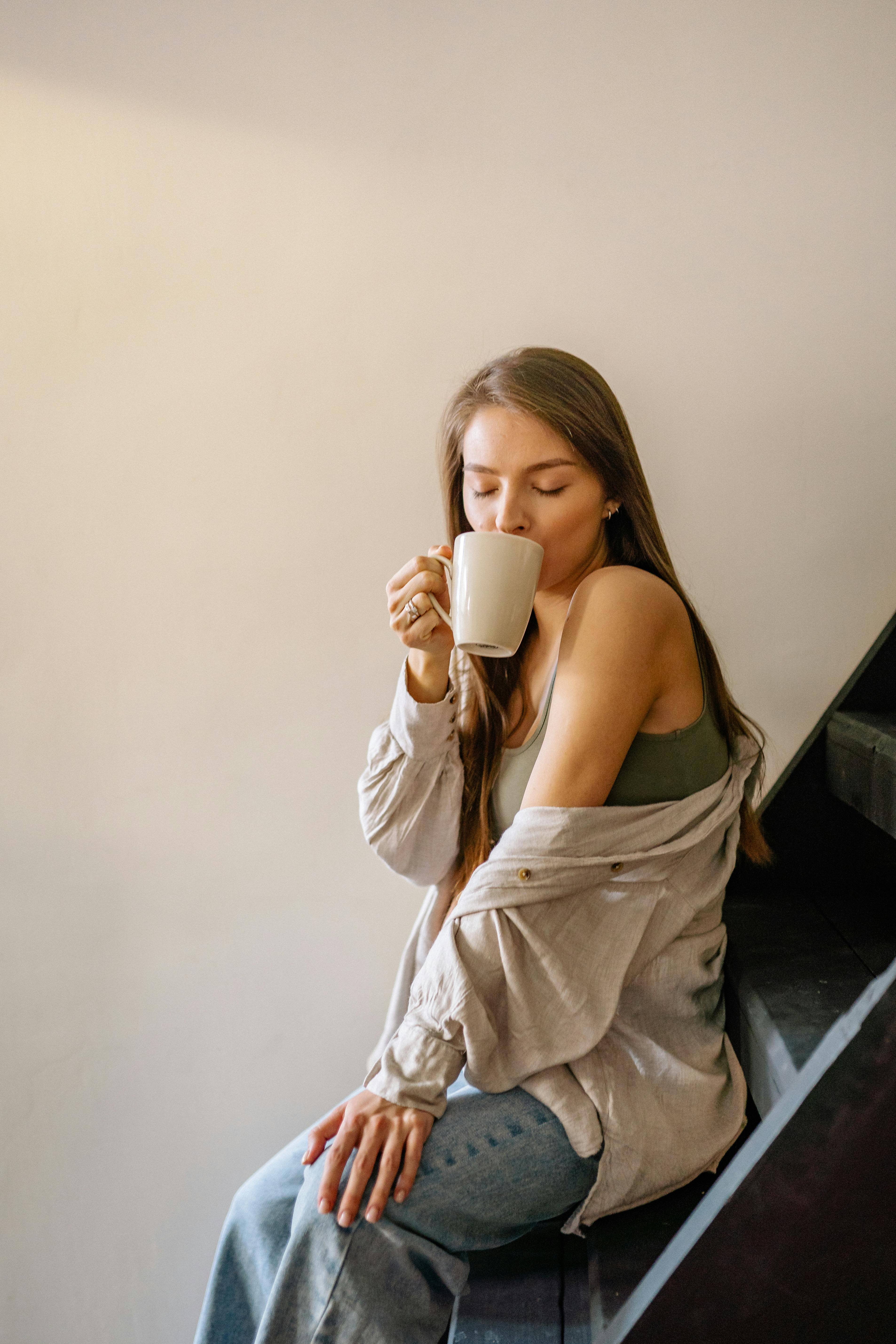 pregnant woman sipping drink on a cup