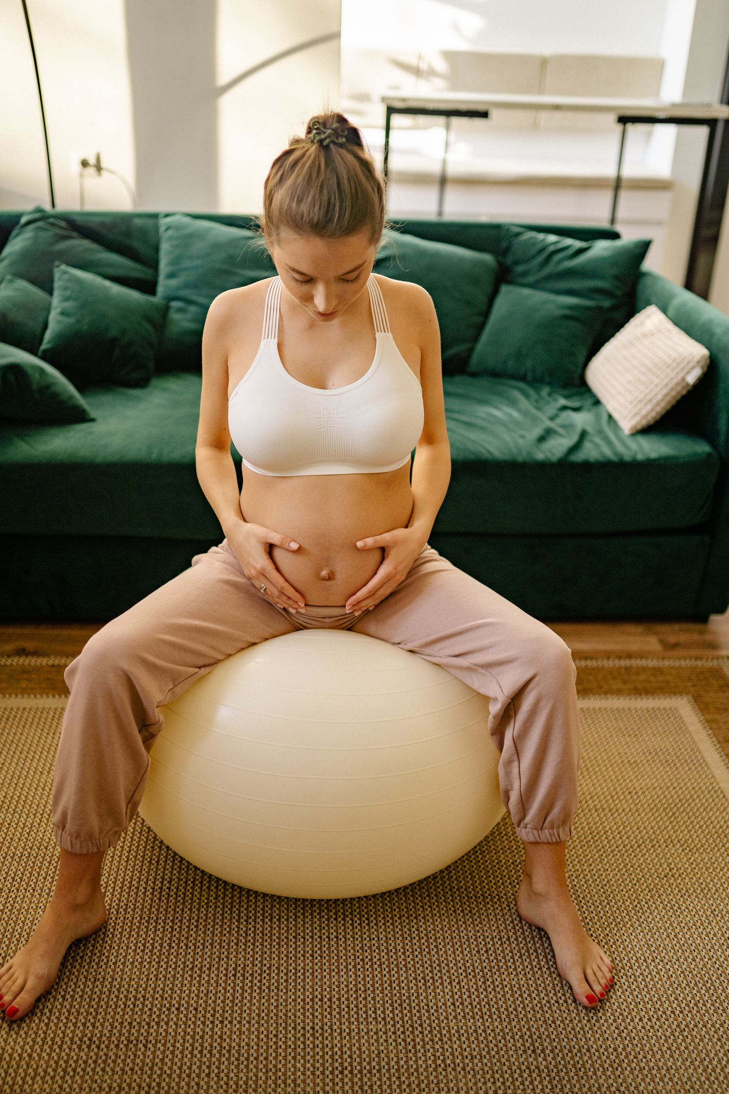 Future maman utilisant un ballon de grossesse dans son salon