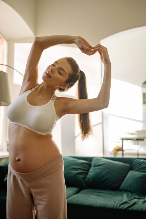 Free A pregnant woman practicing yoga indoors, embracing a healthy lifestyle. Stock Photo