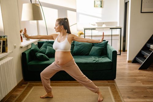 Free A pregnant woman practicing yoga indoors, promoting healthy pregnancy and relaxation. Stock Photo