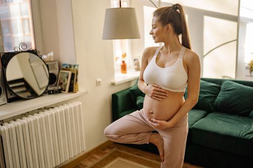 Free Expectant mother practicing yoga at home, embracing healthy pregnancy lifestyle. Stock Photo