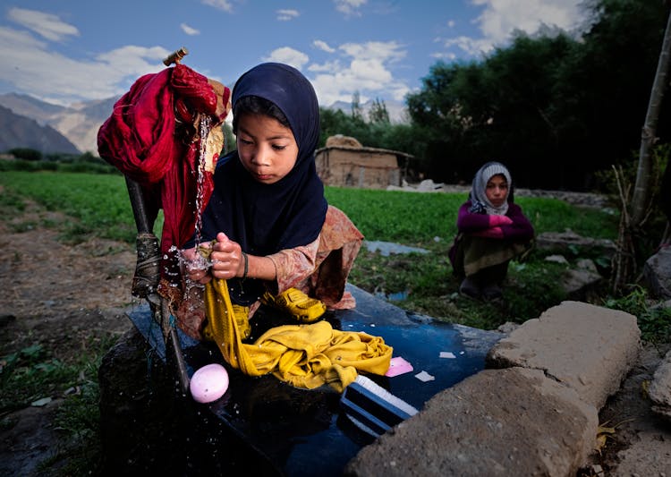 A Girl Washing Clothes By Hand